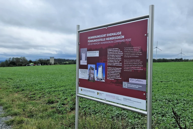 Hinweistafel zum Erinnerungsort Führungsstelle Heinersgrün auf einem Feld bei Mödlareuth