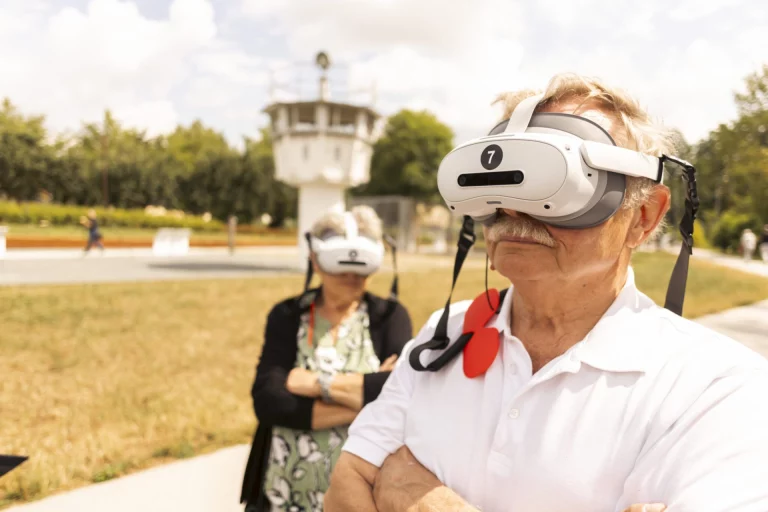 Mann und Frau mit VR-Brillen vor dem Grenzturm im Museum Mödlareuth