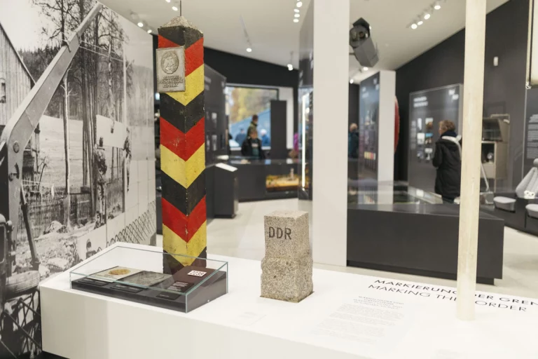 Grenzsäule und Grenzstein mit historischen Fotos in der Ausstellung des Museums Mödlareuth
