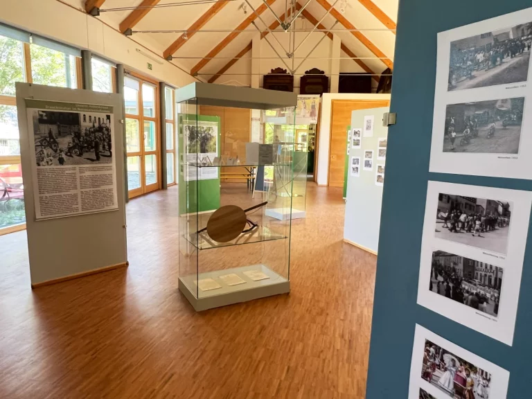 Ausstellungsraum mit Vitrine, Infotafeln und historischen Fotografien zu Wiesenfesten