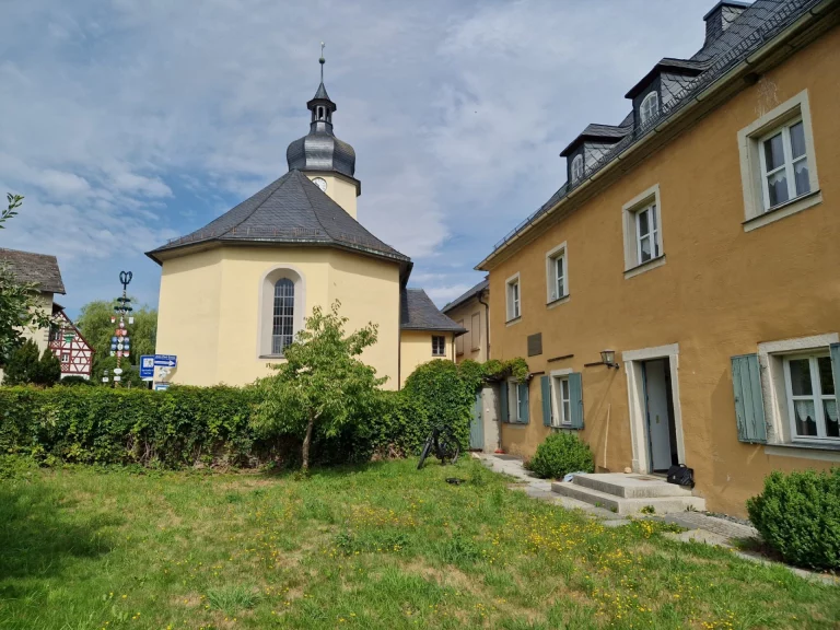 Kirche St. Lorenz und Nebengebäude mit Grünfläche im Innenhof