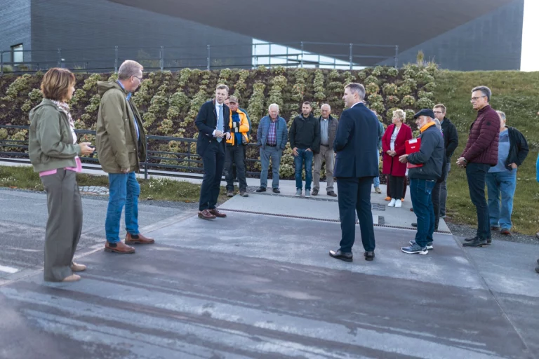 Gruppe von Personen bei einem Ortstermin auf neu gepflastertem Gehweg vor dem Infozentrum Mödlareuth