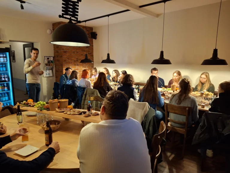 Gruppe junger Erwachsener bei gemeinsamem Abendessen in geselliger Runde