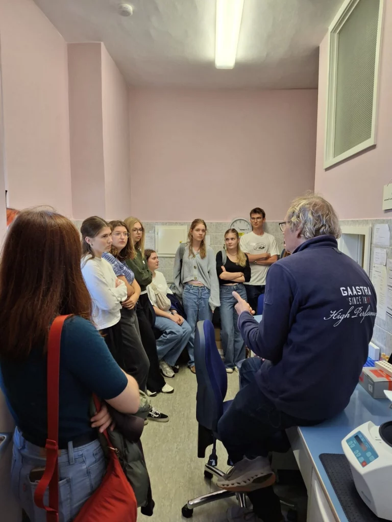 Medizinstudierende verfolgen Erklärungen eines Mitarbeiters im Labor während eines Workshops